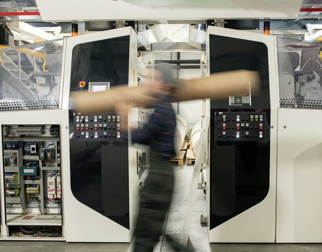 Persoon met buis in een industriële setting
