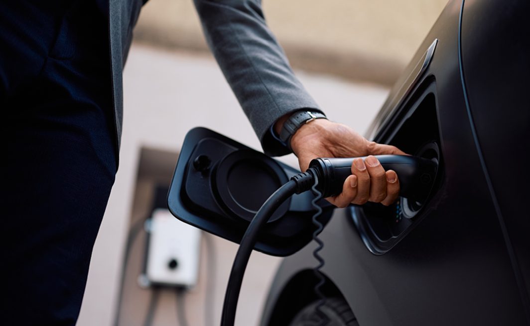 man die zijn auto oplaad
